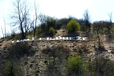 Nápis Trať mládeže na kopci, nad traťou.